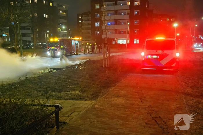 Brandweer blust brandende berg afval