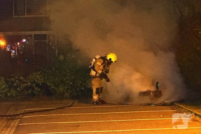 Brandweer blust afvalbrand op parkeerterrein