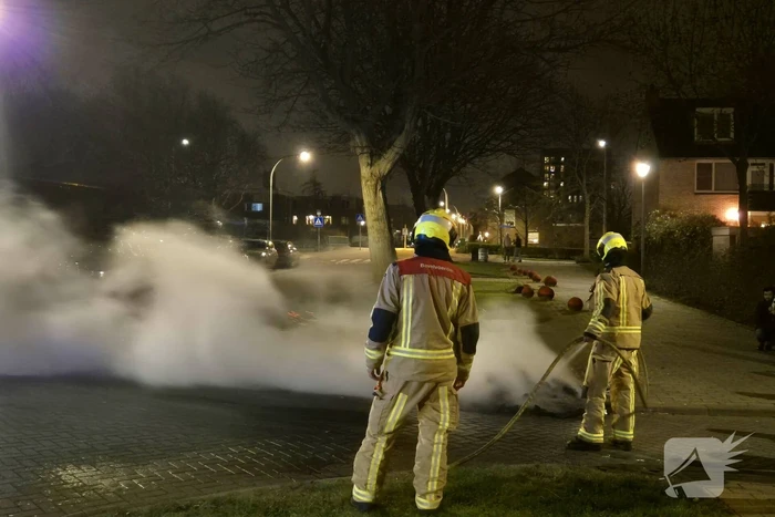 Brandweer blust afvalbrand op straat