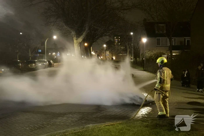 Brandweer blust afvalbrand op straat
