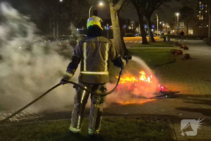 Brandweer blust afvalbrand op straat