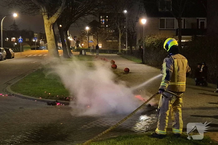 Brandweer blust afvalbrand op straat