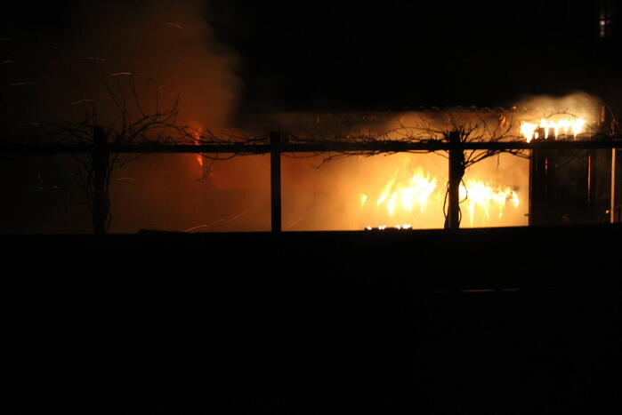Schuur en overkapping verwoest door brand