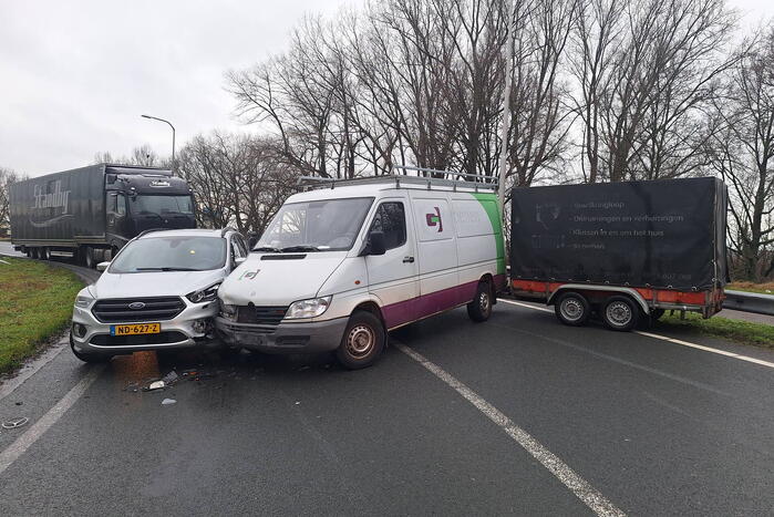 Bestelbus met aanhanger klapt op tegenligger
