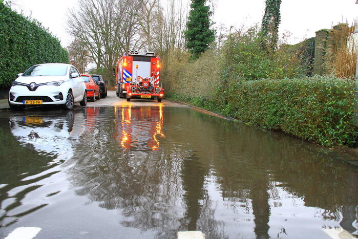 Straat onder water na overstroming riool