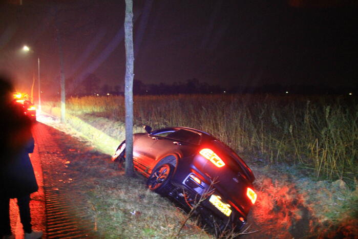 Spekglad wegdek, automobilist belandt in greppel