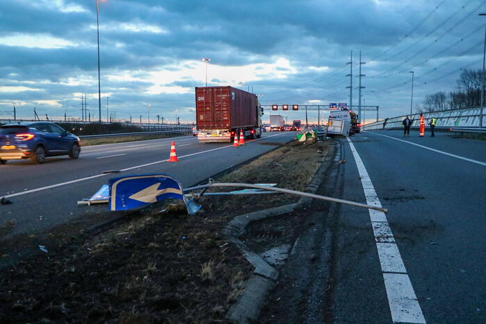 Bestelbus met aanhanger belandt op zijkant