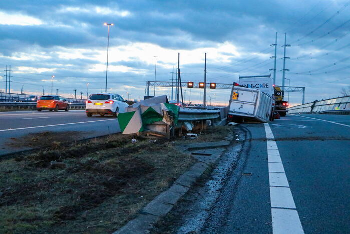 Bestelbus met aanhanger belandt op zijkant