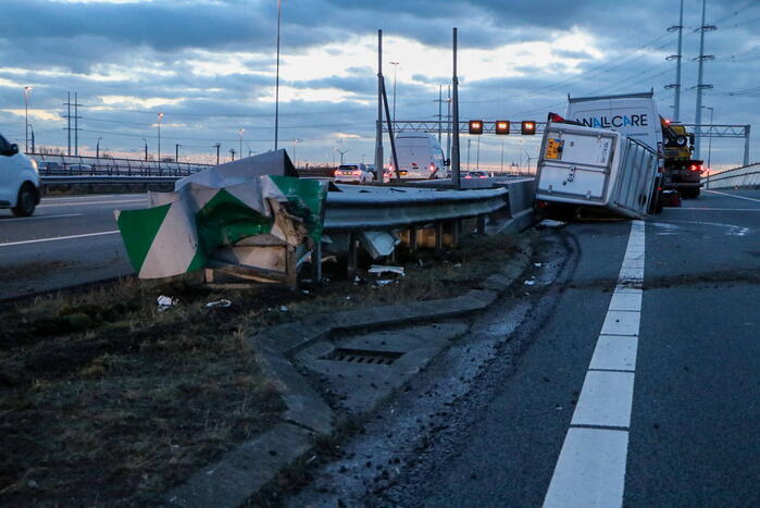 Bestelbus met aanhanger belandt op zijkant