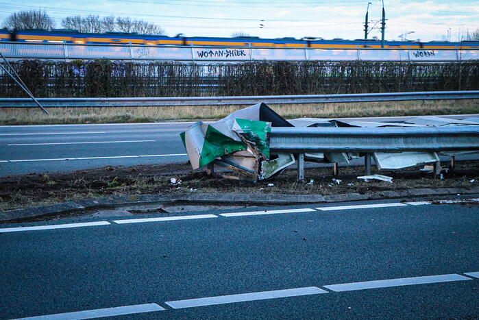Bestelbus met aanhanger belandt op zijkant