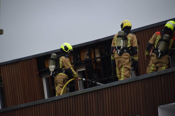 Brandweer blust brandende dakbedekking