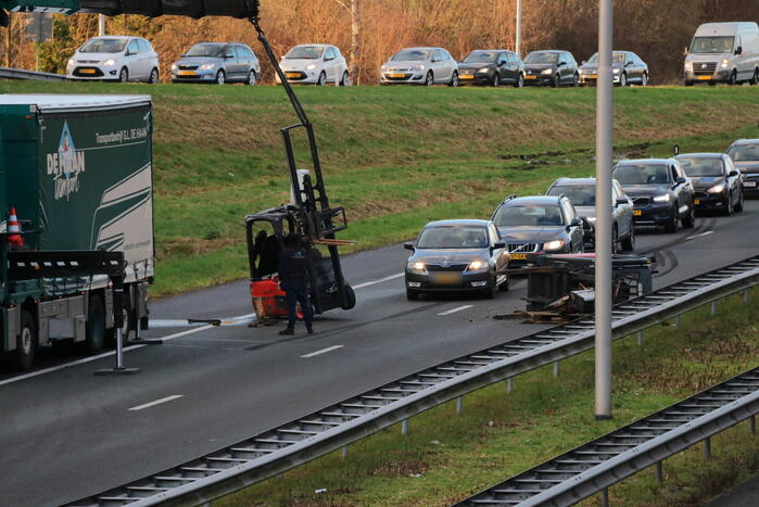 Vrachtwagen verliest twee heftrucks uit aanhanger