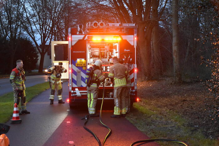 Brandstichting in stapel hout