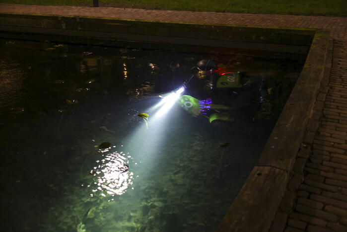 Personen dumpen scooter in vijver met karpers