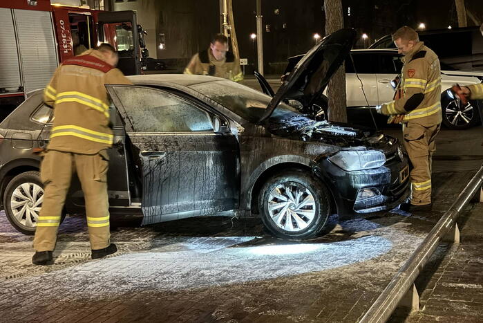 Brandweer blust brand onder motorkap