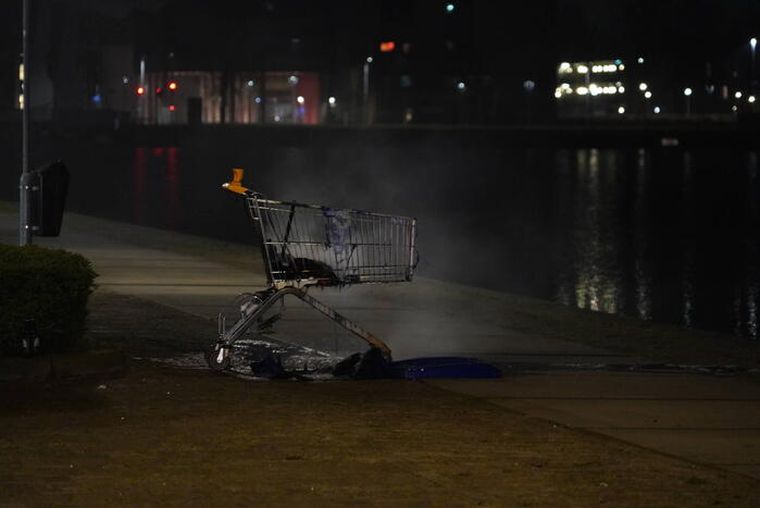 Winkelwagen met afval bij daklozenopvang in brand gestoken
