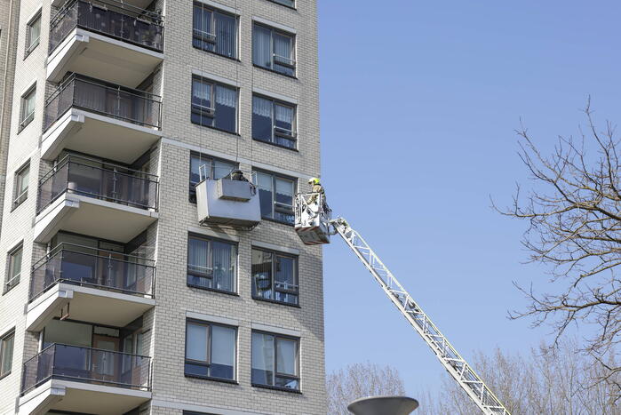 Brandweer haalt persoon uit vastzittende glazenwasserbak