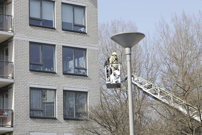 Brandweer haalt persoon uit vastzittende glazenwasserbak