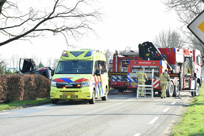 Auto raakt van de weg en belandt op zijkant in voortuin