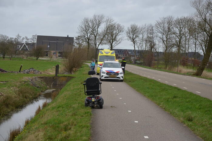 Persoon in scootmobiel raakt te water