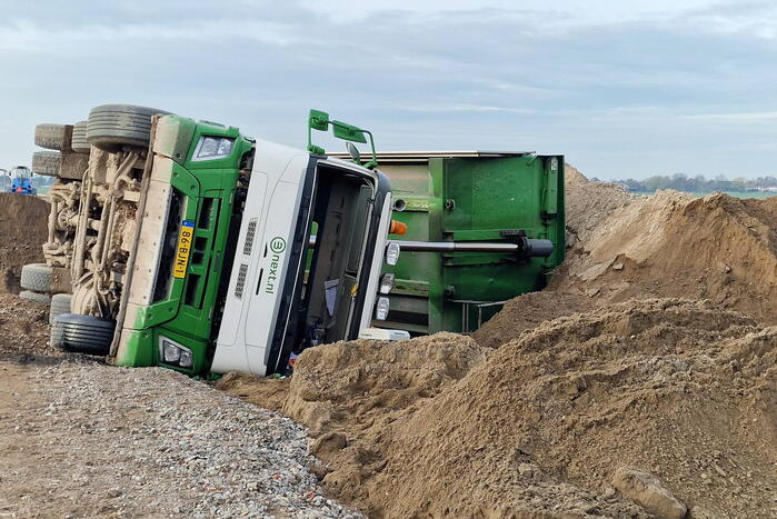 Vrachtwagen kantelt op bouwplaats