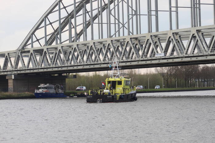 Persoon op bogen van brug, vele hulpdiensten aanwezig