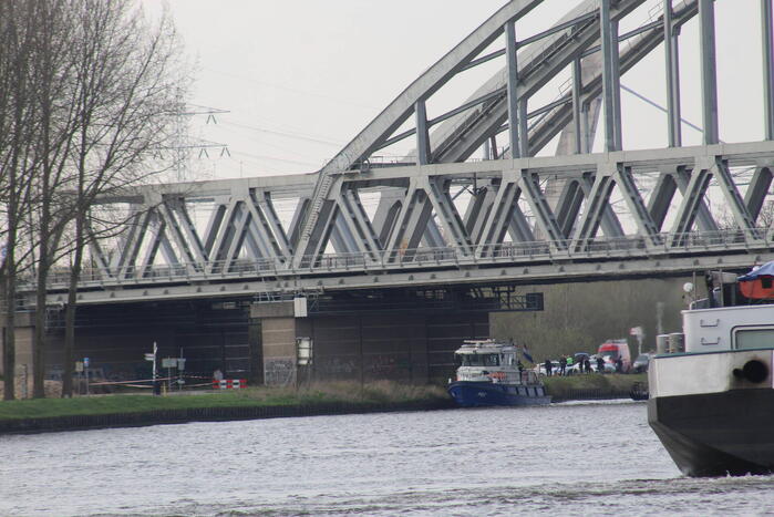 Persoon op bogen van brug, vele hulpdiensten aanwezig