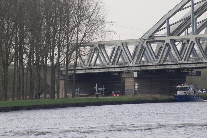 Persoon op bogen van brug, vele hulpdiensten aanwezig