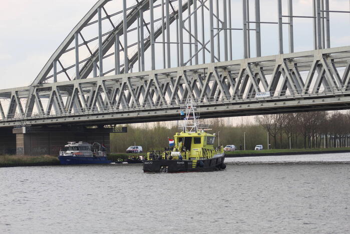 Persoon op bogen van brug, vele hulpdiensten aanwezig