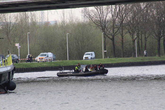 Persoon op bogen van brug, vele hulpdiensten aanwezig
