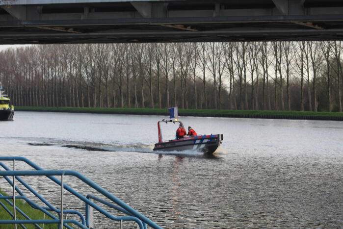 Persoon op bogen van brug, vele hulpdiensten aanwezig