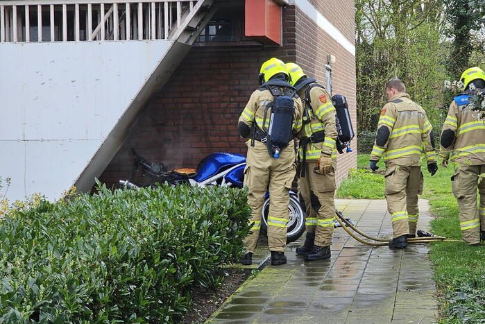 Motor in brand naast flatgebouw