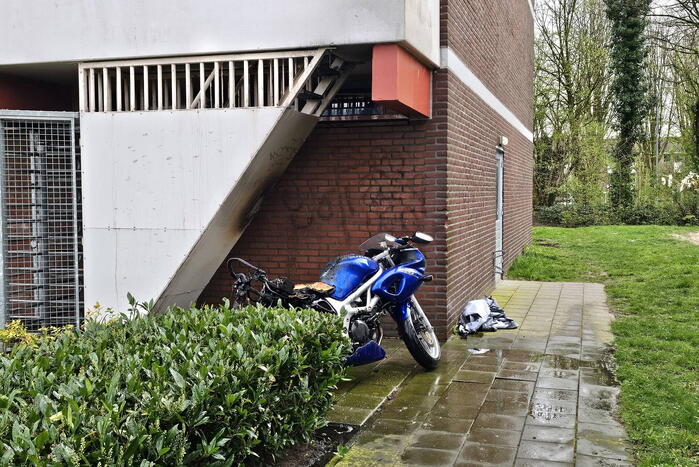 Motor in brand naast flatgebouw