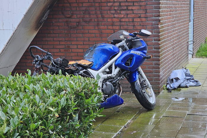 Motor in brand naast flatgebouw