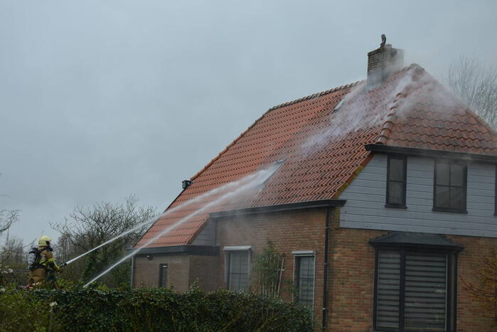 Brandweer blust brand in dak van woonboerderij