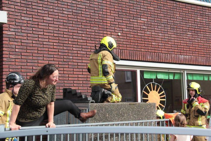 Kind bekneld tussen hek en betonnen container