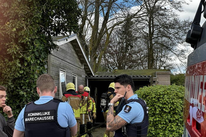 Brandweer blust brand achter woning