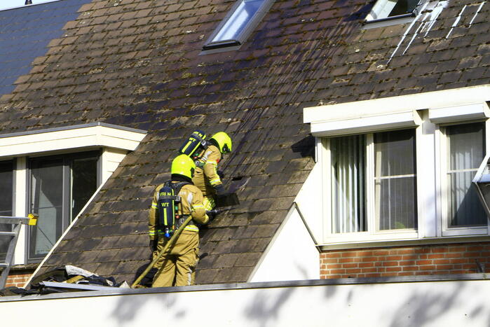 Brandweer breekt dak open om brand te bestrijden