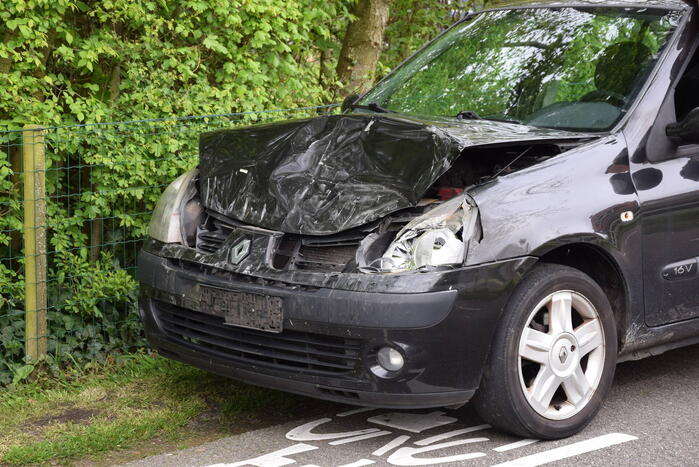 Schade bij ongeval tussen twee auto's en motor