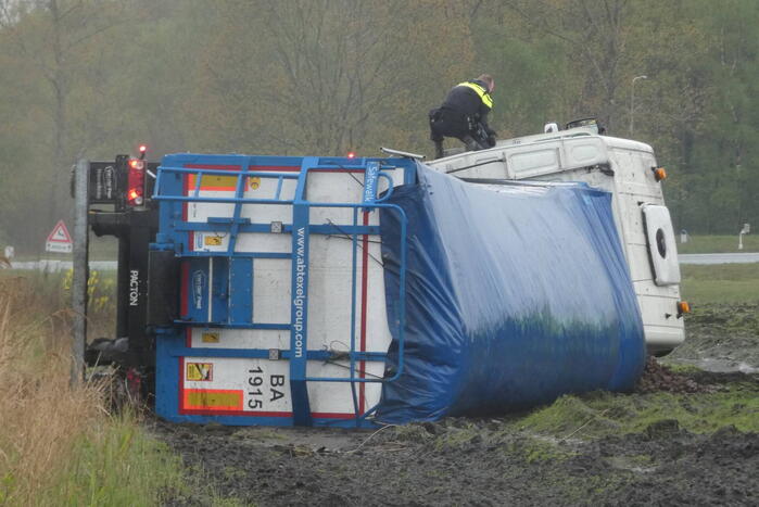 Vrachtwagen raakt van de weg en kantelt