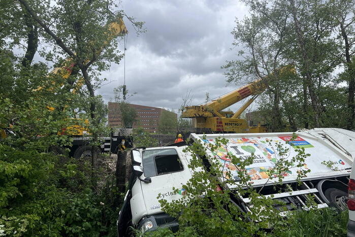 Vuilniswagen glijdt de bosschages in