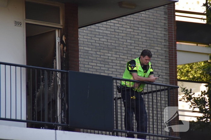Afval voor voordeur in brand bewoner door brandweer naar buiten begeleidt