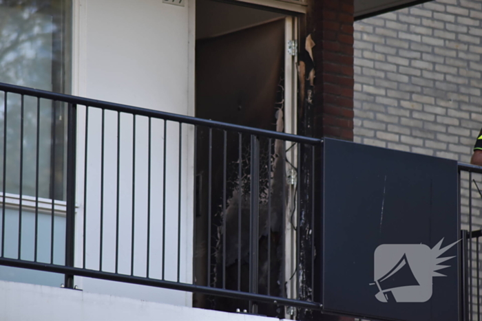 Afval voor voordeur in brand bewoner door brandweer naar buiten begeleidt