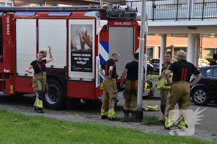 Afval voor voordeur in brand bewoner door brandweer naar buiten begeleidt