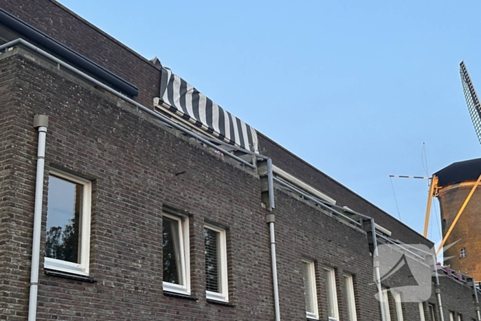 Zonnescherm waait kapot, brandweer ingezet
