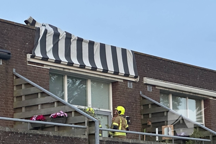 Zonnescherm waait kapot, brandweer ingezet