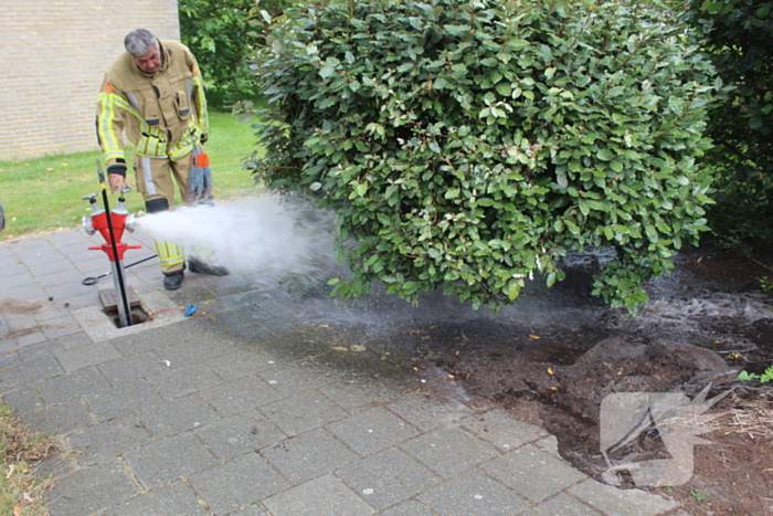 Brandweer blust buitenbrand met water uit brandkraan