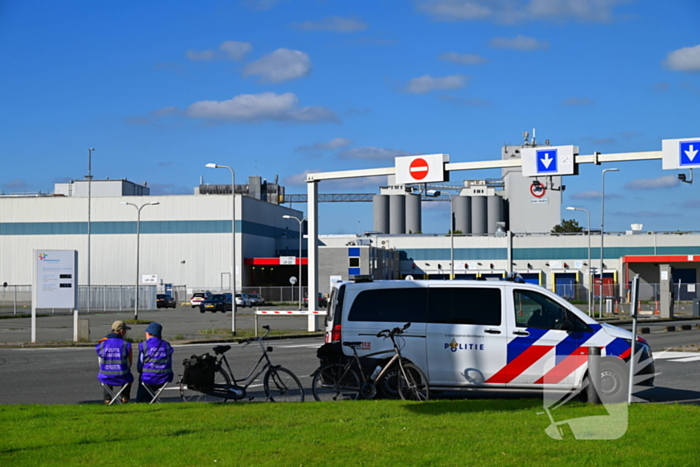 Demonstranten klimmen over hekken van zuivel fabrikant