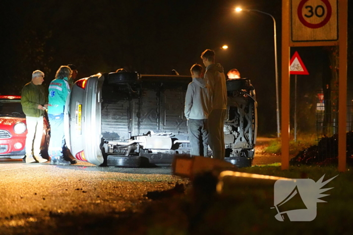 Auto botst tegen lantaarnpaal en belandt op zijkant