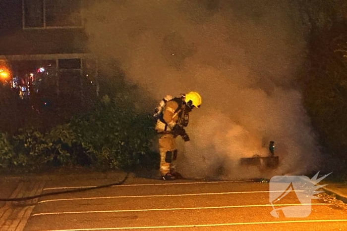 Brandweer blust afvalbrand op parkeerterrein